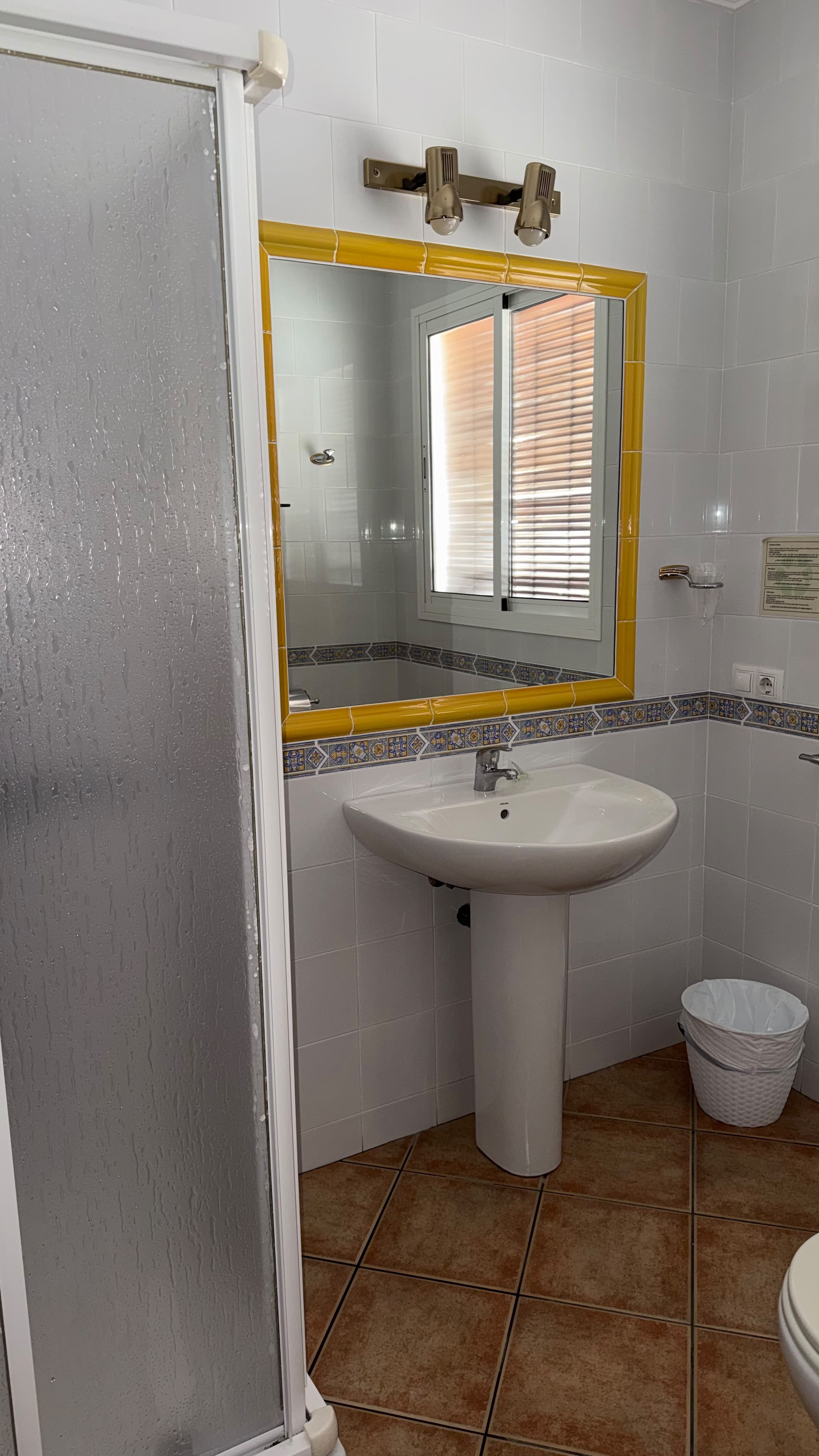 Baño con azulejos amarillos en Hostal Santa Cruz