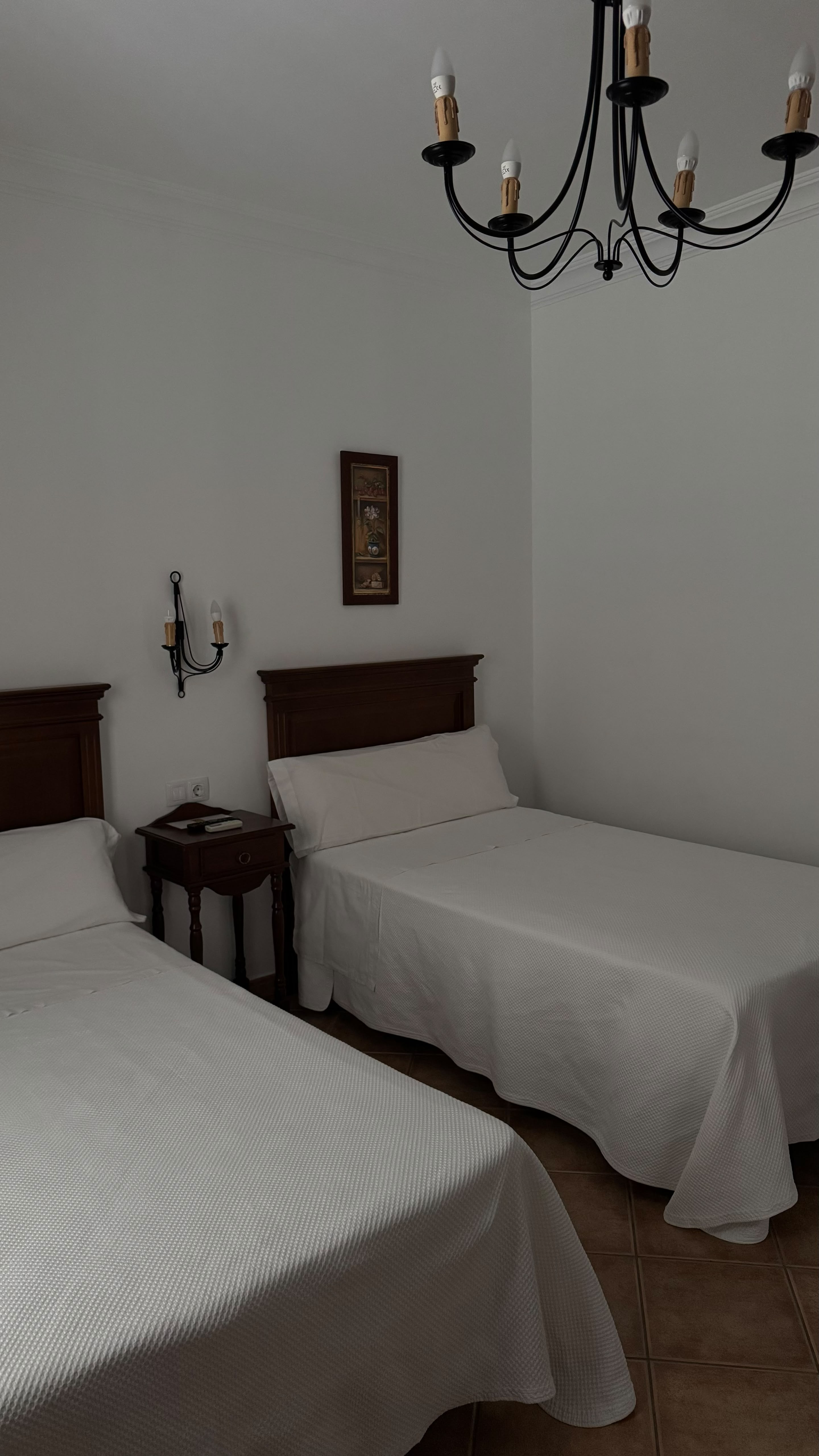 Habitación doble blanca con espejo de madera en Hostal Santa Cruz