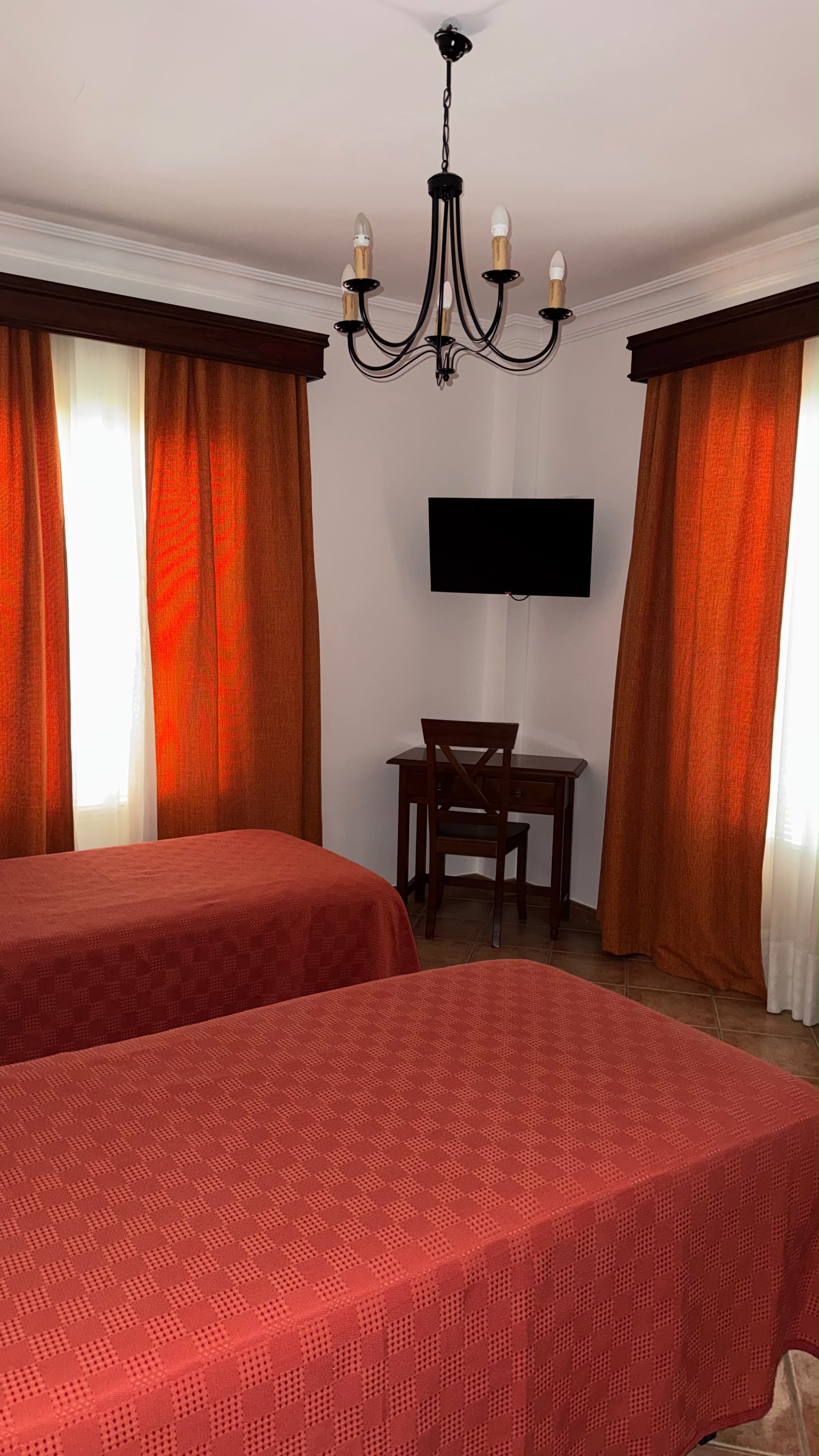 Habitación doble clásica con cortinas naranjas en Hostal Santa Cruz