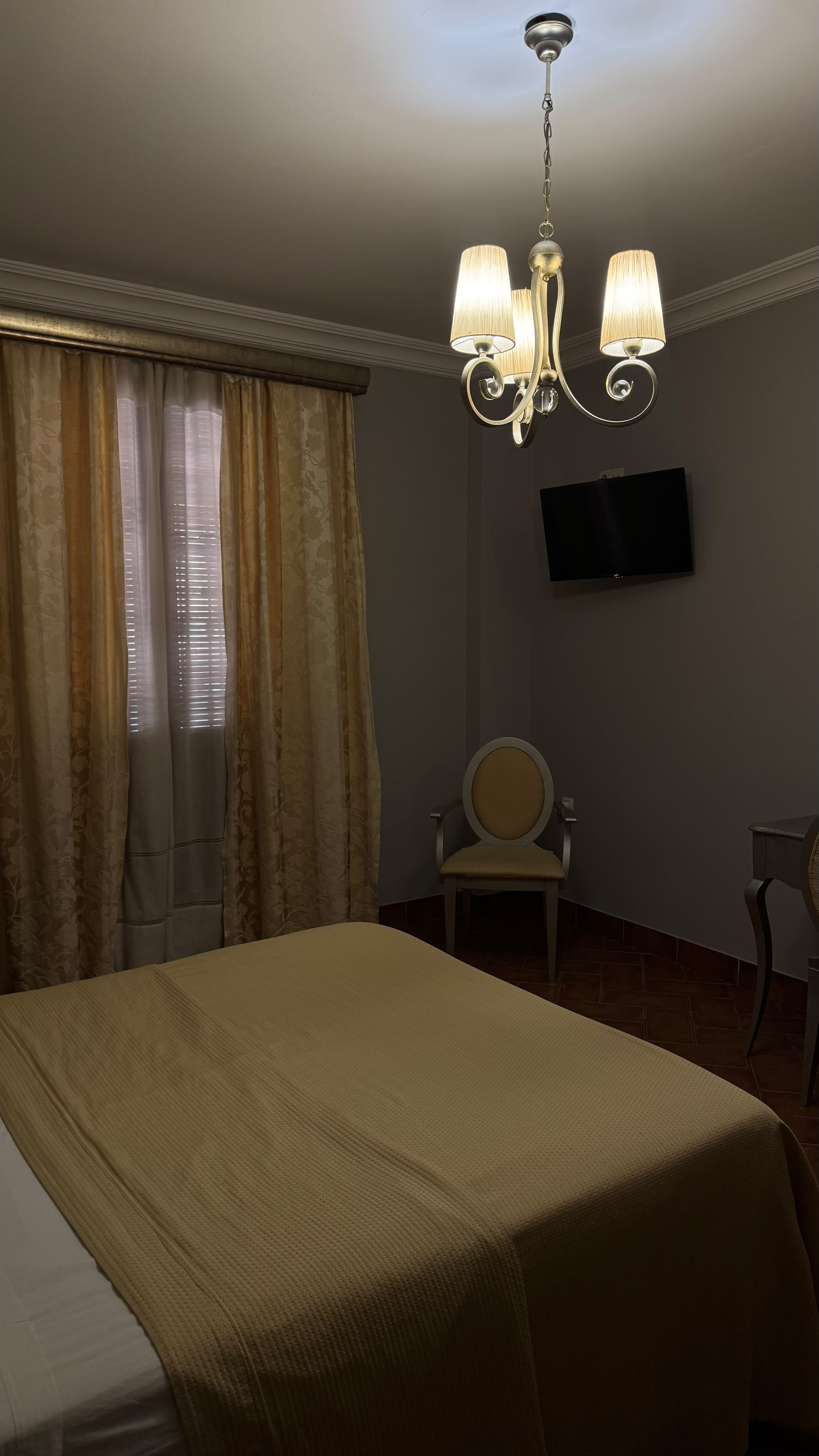 Habitación doble reformada con cortinas doradas en Hostal Santa Cruz