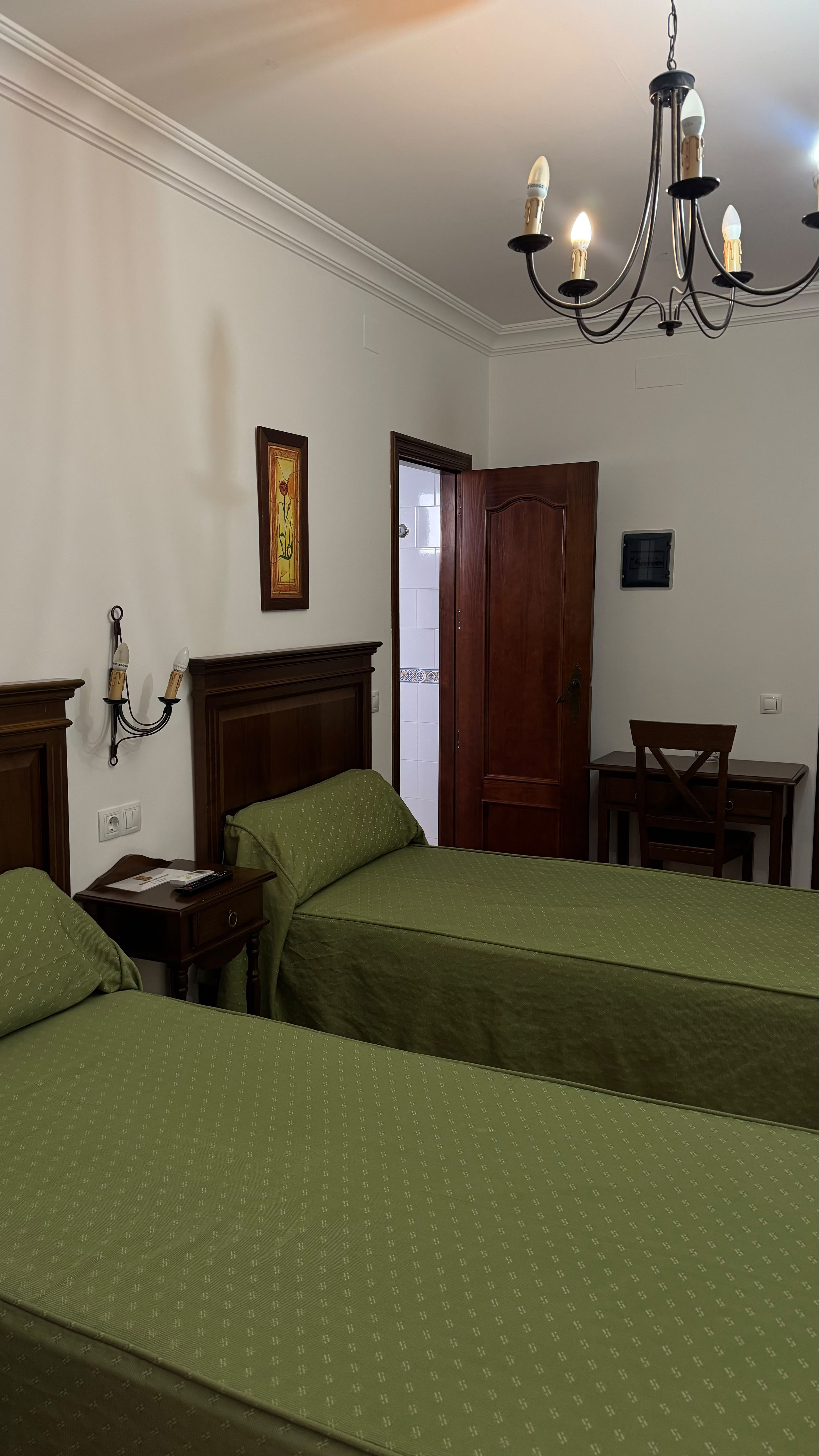 Habitación doble con colchas verdes en Hostal Santa Cruz